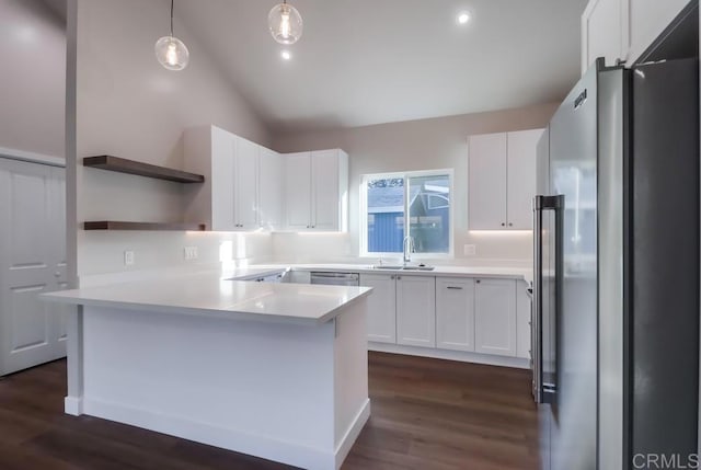 kitchen with appliances with stainless steel finishes, decorative light fixtures, sink, white cabinetry, and lofted ceiling