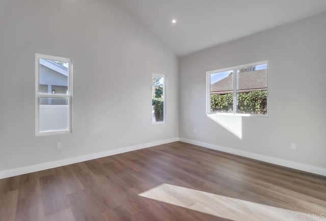 spare room with light hardwood / wood-style floors and high vaulted ceiling