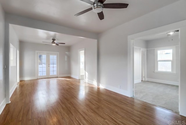 spare room with a healthy amount of sunlight, ceiling fan, and french doors