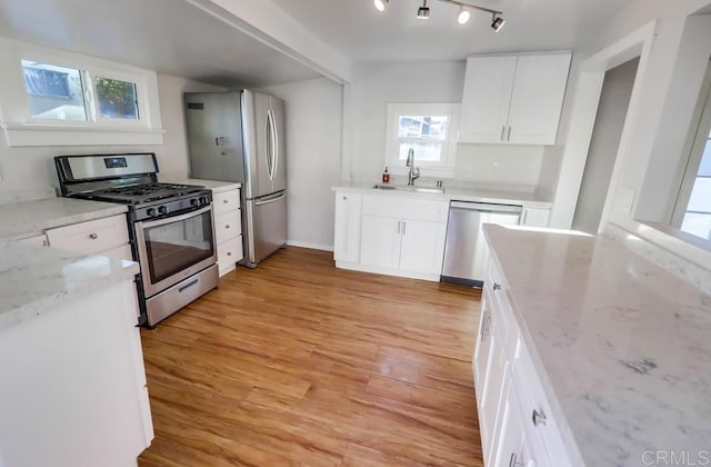 kitchen with light hardwood / wood-style floors, sink, white cabinets, and stainless steel appliances