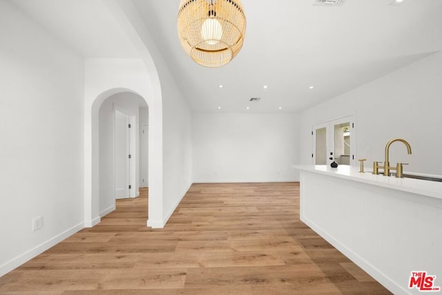 interior space with sink, french doors, and light wood-type flooring