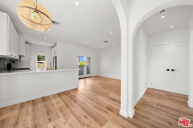 interior space featuring light wood-type flooring, french doors, and sink