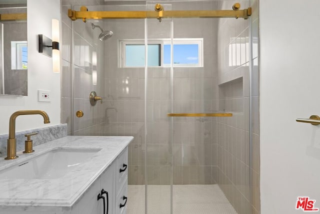 bathroom with vanity and a shower with door