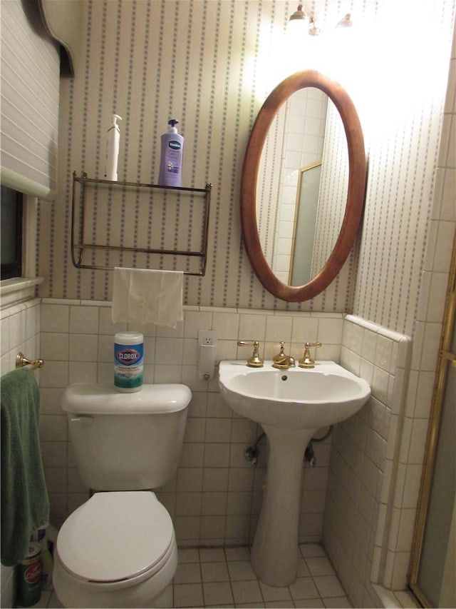 bathroom featuring toilet, tile walls, sink, and tile patterned floors