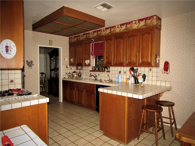 kitchen featuring tile counters, light tile patterned floors, kitchen peninsula, and backsplash