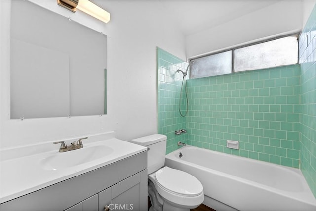 full bathroom featuring tiled shower / bath combo, vanity, and toilet