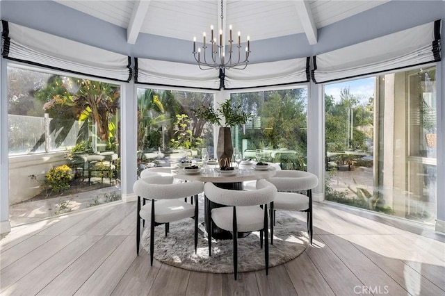 sunroom / solarium with a chandelier and beamed ceiling