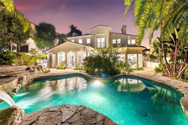 pool at dusk with pool water feature