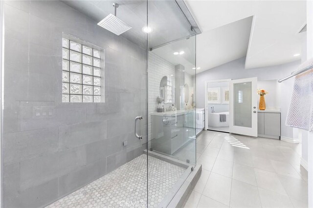 bathroom featuring vaulted ceiling, tile patterned floors, and a shower with shower door