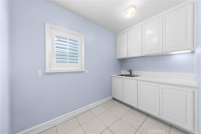 laundry room featuring light tile patterned flooring and sink