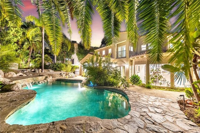 pool at dusk with pool water feature