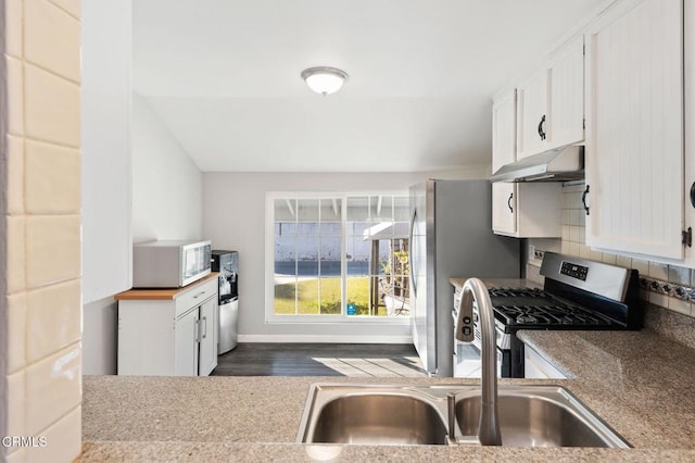 kitchen featuring stainless steel appliances, decorative backsplash, white cabinets, and sink