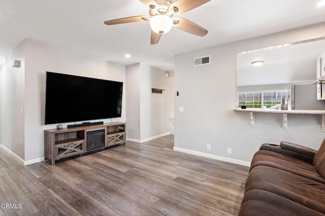 living room with ceiling fan and hardwood / wood-style floors