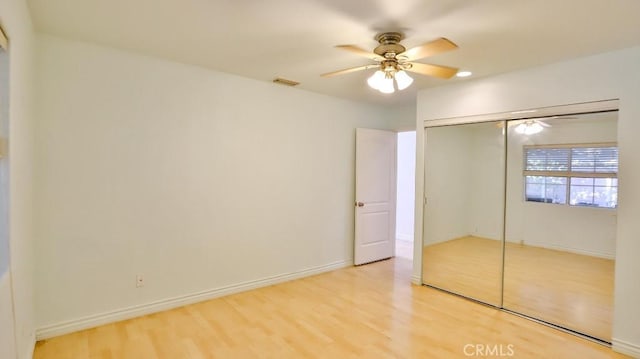 unfurnished bedroom featuring ceiling fan, a closet, and hardwood / wood-style floors