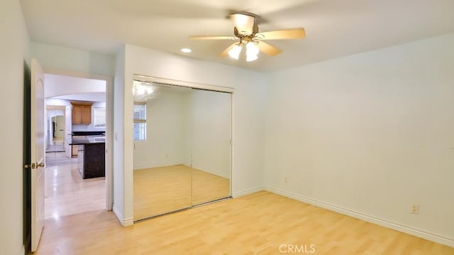 unfurnished bedroom featuring a closet, light hardwood / wood-style floors, and ceiling fan