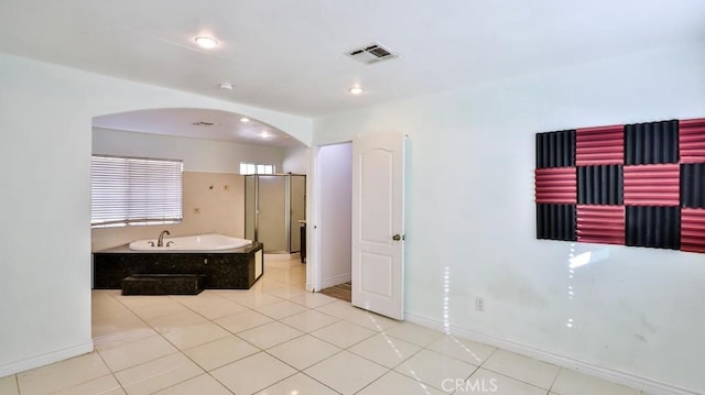 bathroom with a tub to relax in and tile patterned floors