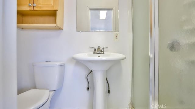 bathroom with an enclosed shower and toilet