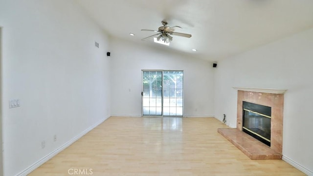 unfurnished living room featuring light wood-type flooring, ceiling fan, a high end fireplace, and lofted ceiling