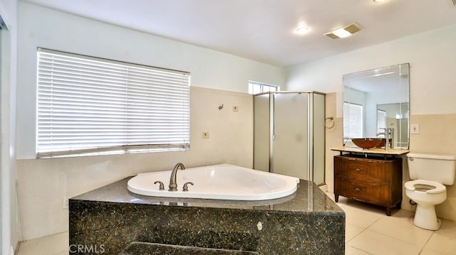 full bathroom featuring toilet, vanity, tile patterned floors, and independent shower and bath