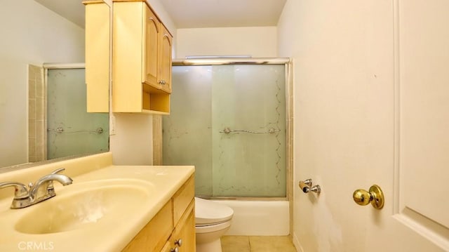 full bathroom featuring toilet, bath / shower combo with glass door, tile patterned floors, and vanity