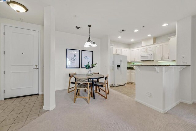 carpeted dining area featuring a notable chandelier