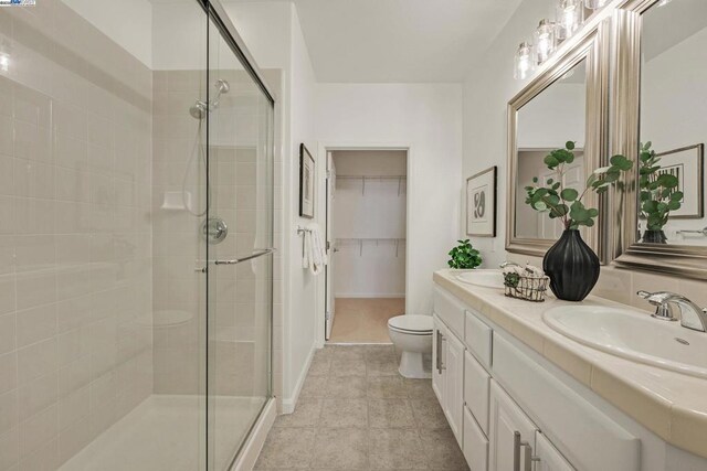 bathroom with walk in shower, vanity, and toilet