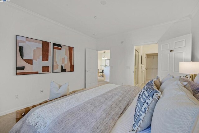 bedroom featuring a closet, a spacious closet, and crown molding