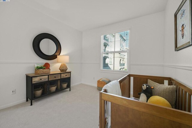 carpeted bedroom featuring a nursery area