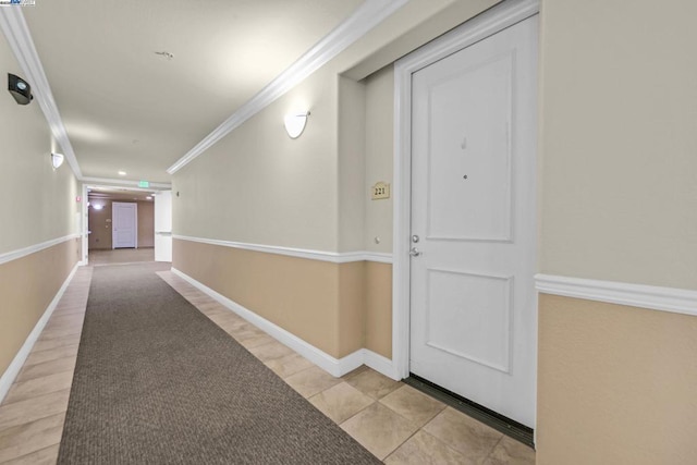 hallway featuring light tile patterned flooring and crown molding