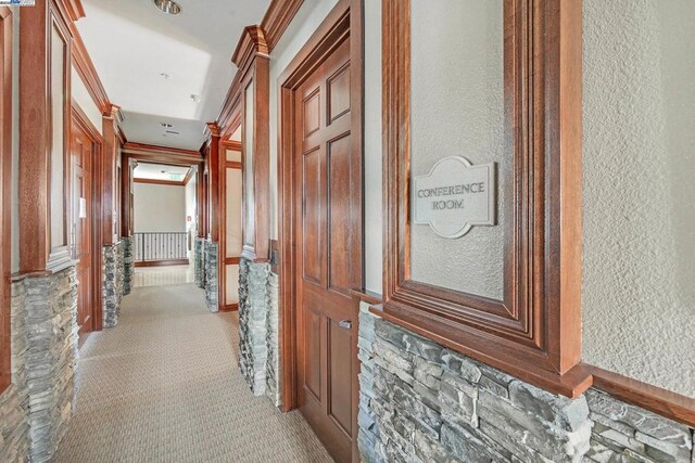 hallway with light carpet and crown molding