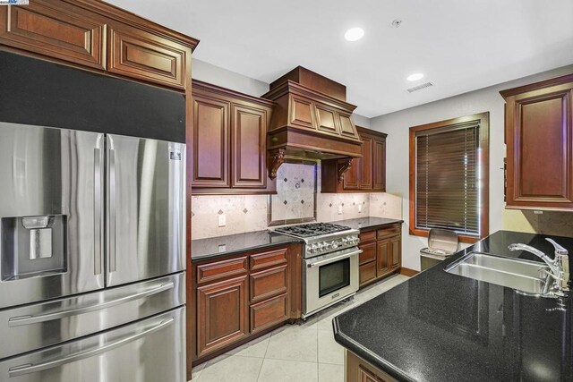 kitchen featuring sink, backsplash, light tile patterned floors, and stainless steel appliances