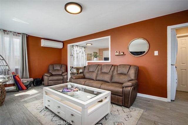 living room with light hardwood / wood-style floors and a wall mounted AC