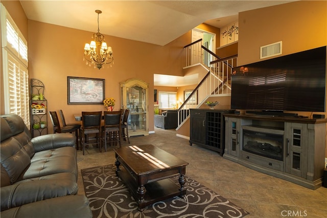 living room with high vaulted ceiling and a notable chandelier