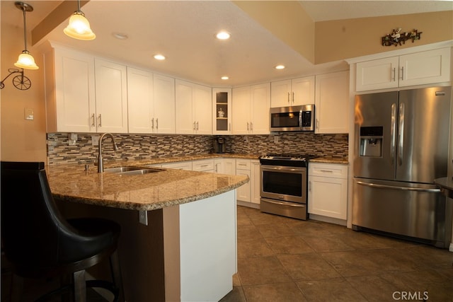 kitchen with sink, stainless steel appliances, white cabinets, and kitchen peninsula