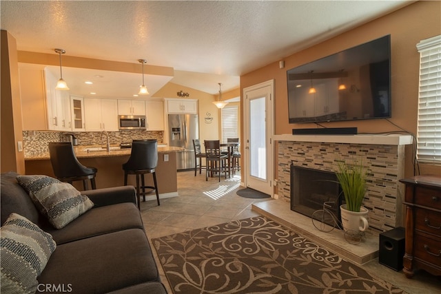 tiled living room featuring lofted ceiling and a fireplace