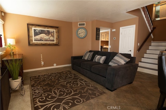 living room featuring dark tile patterned flooring and a textured ceiling