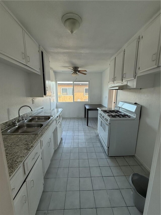 kitchen featuring ceiling fan, white gas stove, white cabinets, and sink