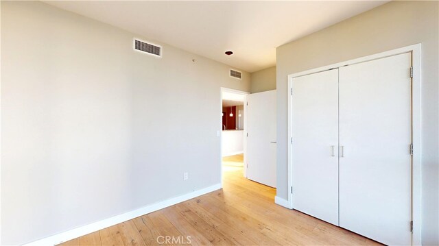 unfurnished bedroom with a closet and light hardwood / wood-style floors