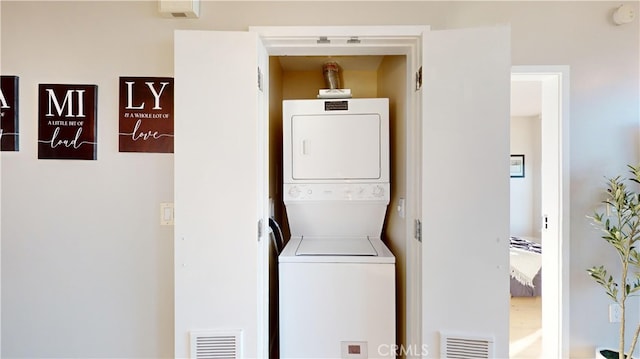 laundry room with stacked washing maching and dryer