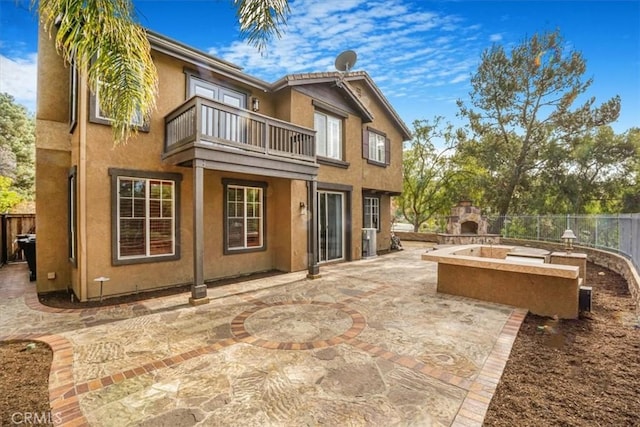 rear view of house with a balcony and a patio