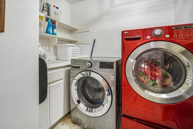 laundry area with cabinets and washer and clothes dryer