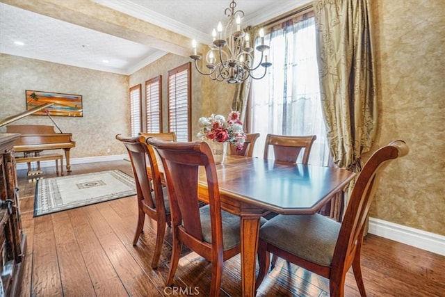 dining room with a chandelier, crown molding, and hardwood / wood-style flooring