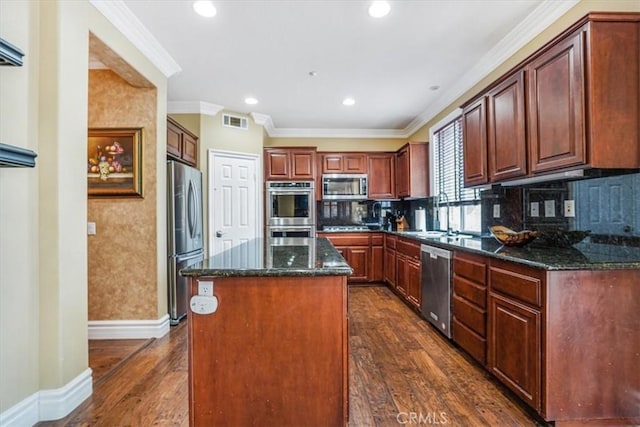 kitchen featuring dark stone countertops, dark hardwood / wood-style flooring, stainless steel appliances, and a kitchen island