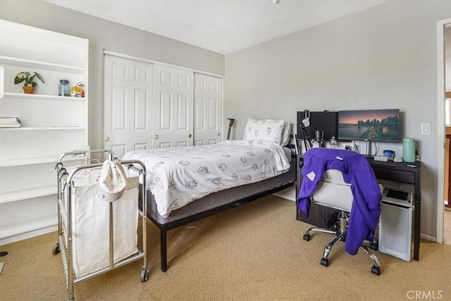 bedroom featuring light colored carpet and a closet