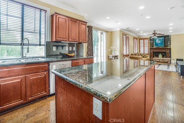 kitchen with a kitchen island, crown molding, dishwasher, and sink