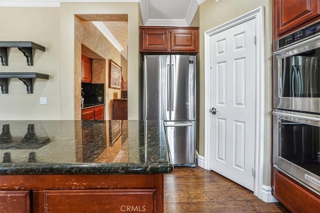 kitchen featuring dark hardwood / wood-style flooring, dark stone countertops, crown molding, and stainless steel appliances