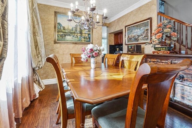 dining space featuring dark wood-type flooring, ornamental molding, and a notable chandelier