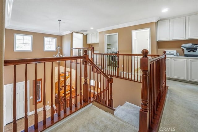 stairs with carpet floors and crown molding