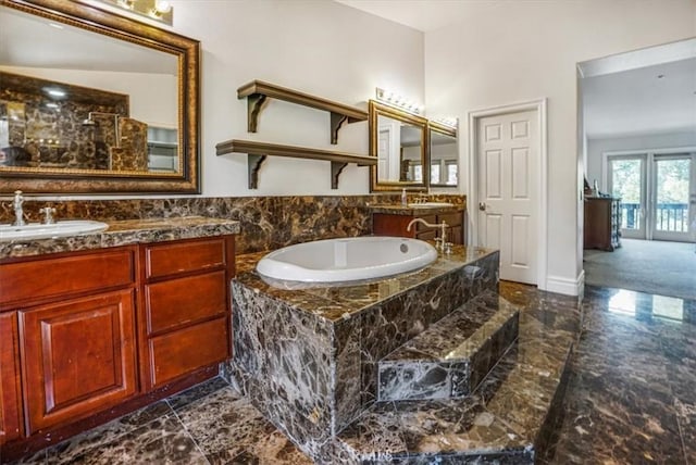 bathroom with tiled bath and vanity