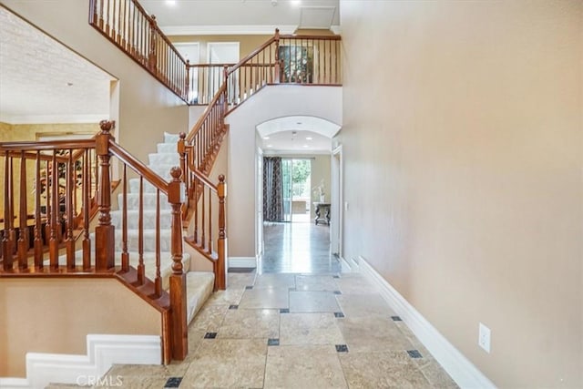 foyer entrance featuring a high ceiling and ornamental molding